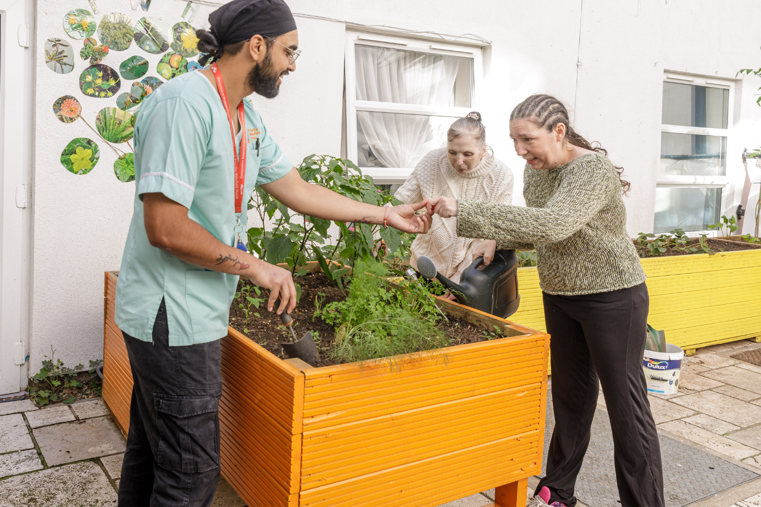 Care home worker with clients in garden