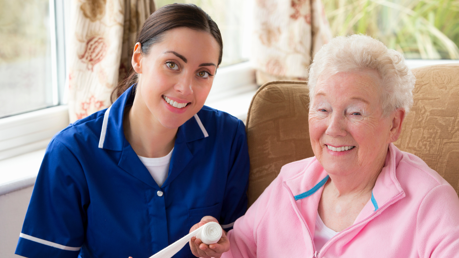 A nurse and a care home guest smile together