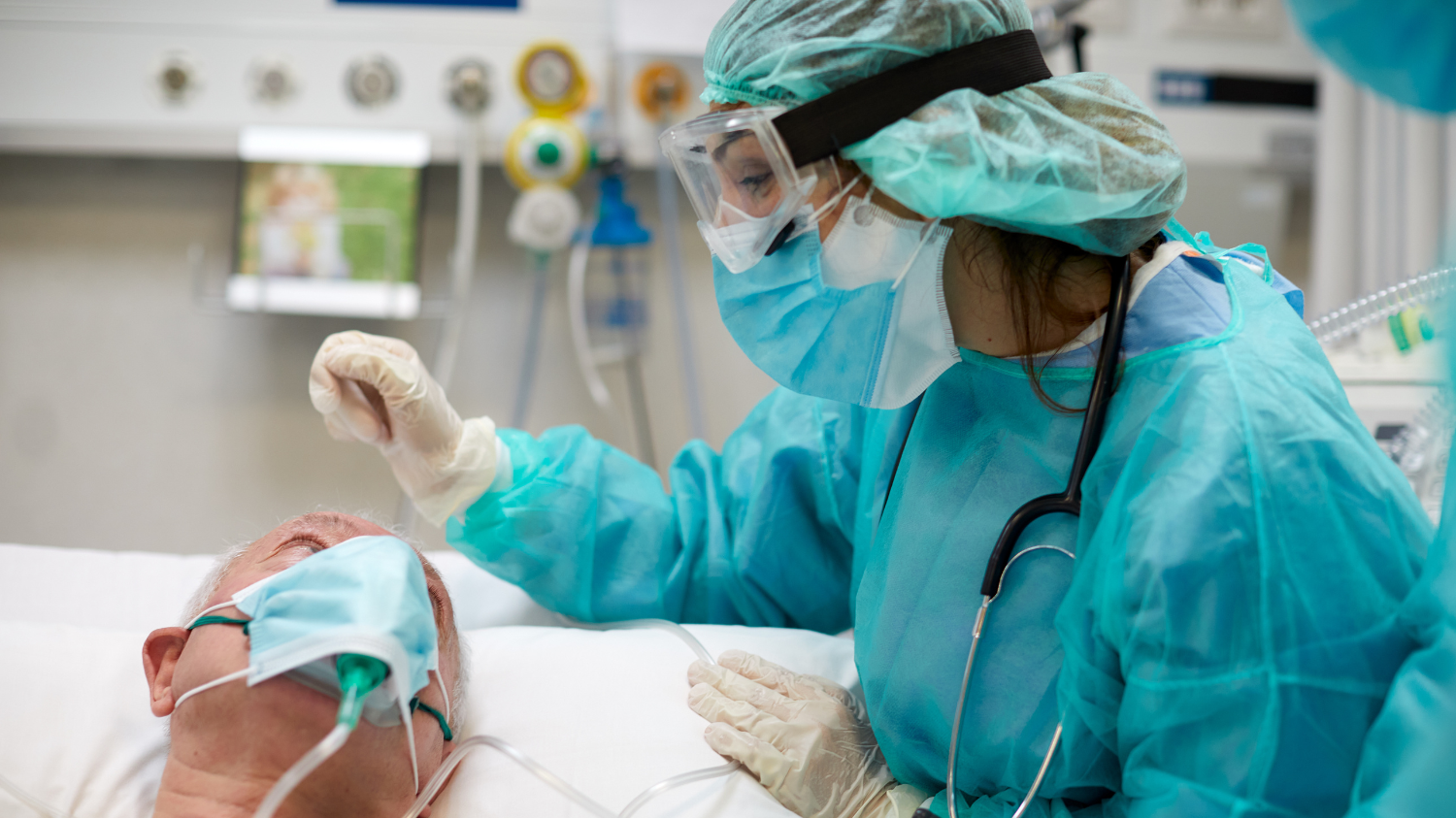A nurse in PPE tends to a patient