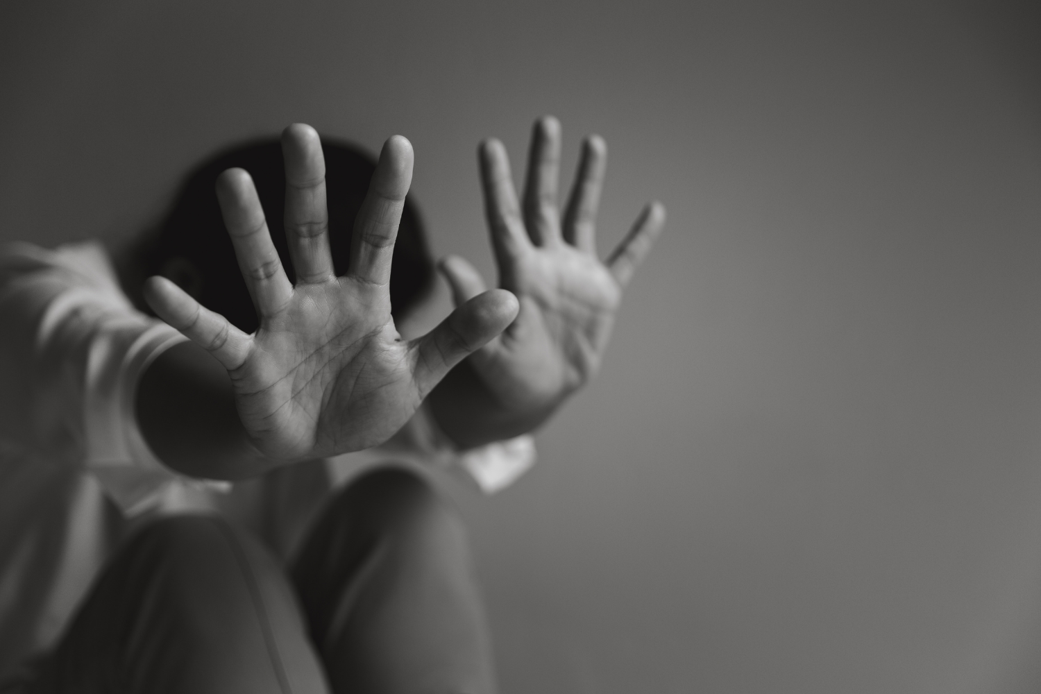 Women sat with head down and hands lifted