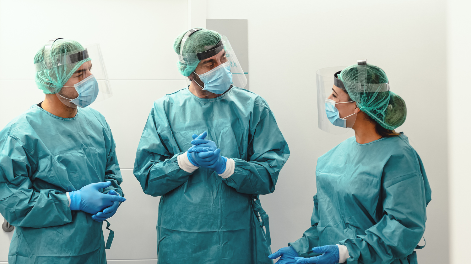 Nurses in PPE discuss a patient