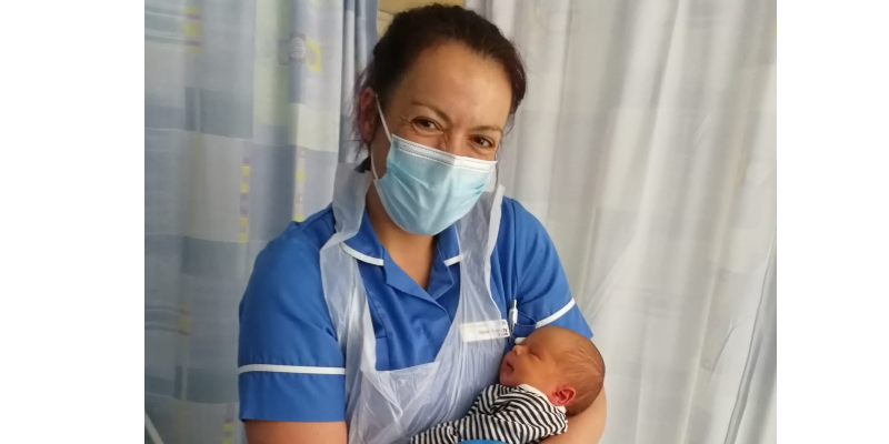 Image of midwife Claire holding new born baby