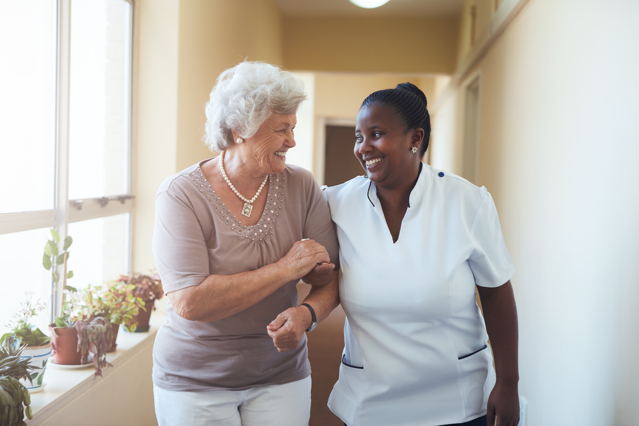 Female Carer with Elderly Lady laughing and hugging