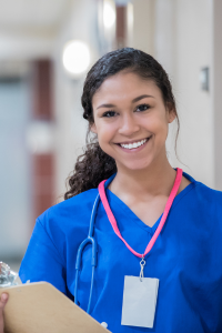 Nurse smiling on ward with clipboard
