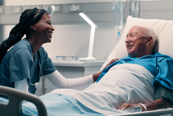 Caring for emotionally vulnerable people Nurse sitting by a male patient's bed
