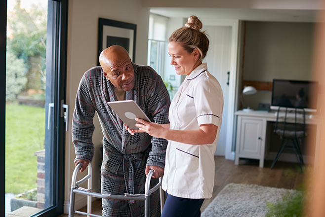 Nurse using a tablet with a patient