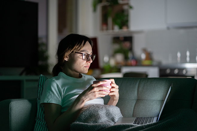 A woman looking at her laptop in the dark