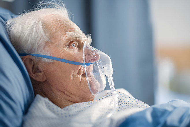 An elderly man in an oxygen mask