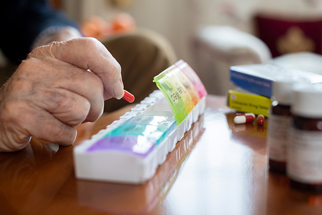 The hands of an elderly person taking medication
