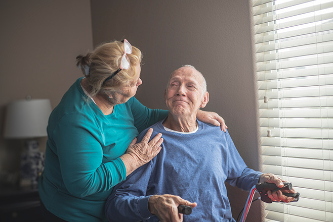 Lady giving a man who is smiling a side hug