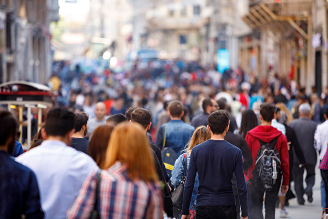 A crowd of people walking along a street