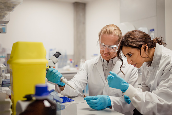Woman and a man looking through a microscope