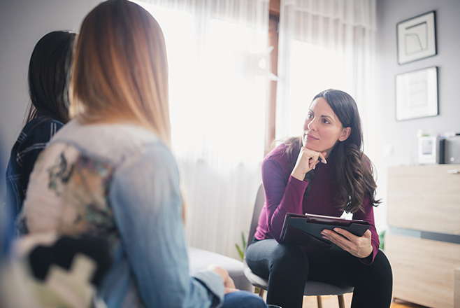 Teenage girl speaking to woman