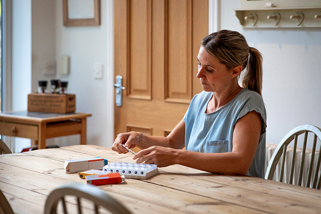 Woman organising her daily tablets at home