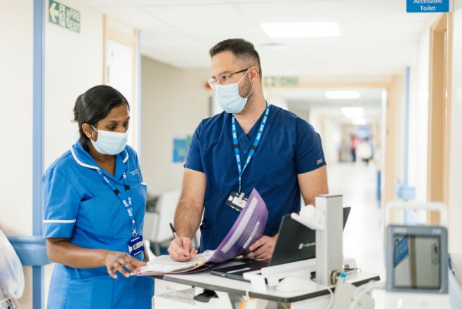 Female and male nurse looking at document together