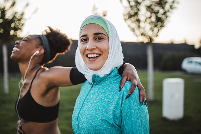 A woman with her arm around another woman and both smiling