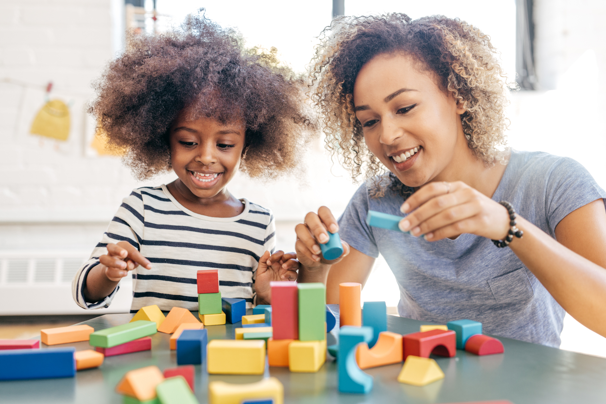 Woman and a girl playing with wooden blocks
