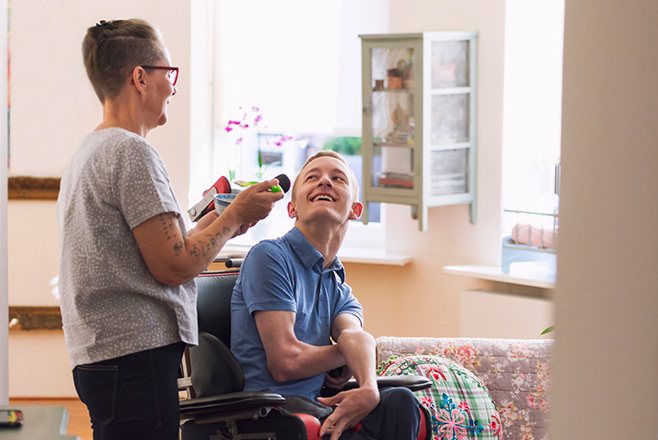 Man in wheelchair laughing with a woman