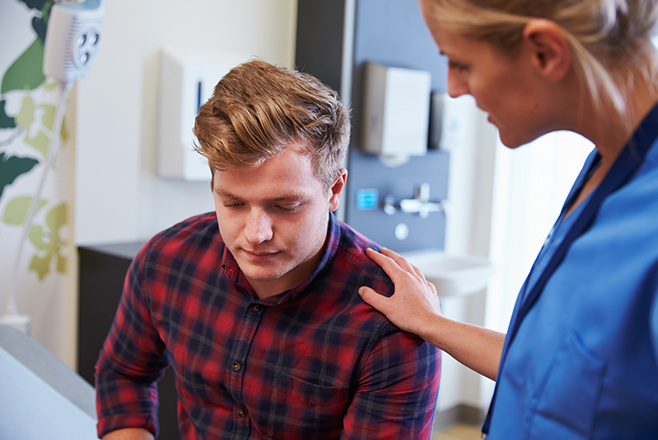Female nurse with hand on the shoulder of male patient