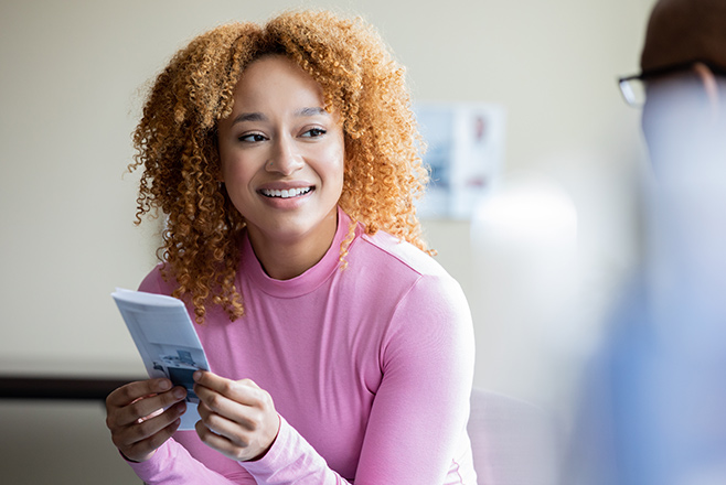 Lady holding a leaflet and smiling