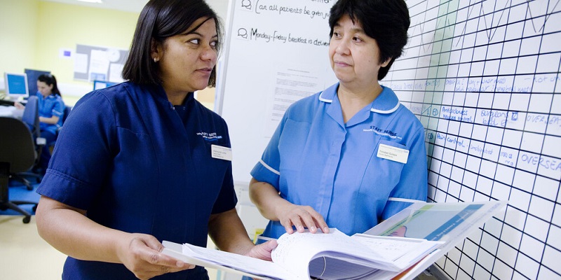 A deputy sister and a staff nurse doing paperwork