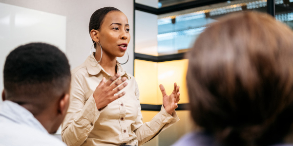 female leader talking animatedly with her hands as two people listen