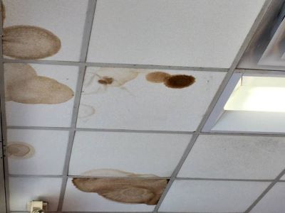 A ceiling with water and damp stains