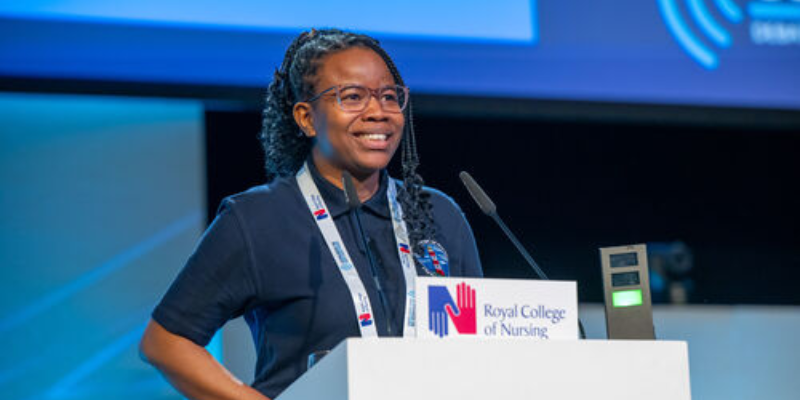 Tolulope Oladimeji, South West member speaking at the podium in the auditorium at RCN Congress 2026