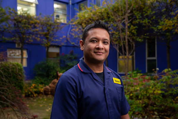 Image of male nurse outside a blue building