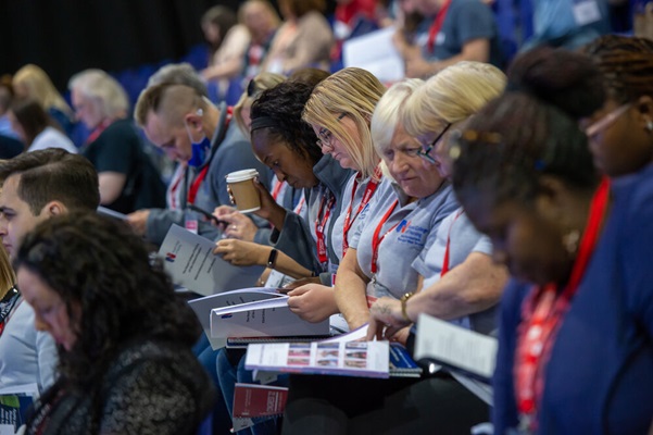 A row of members reading notes