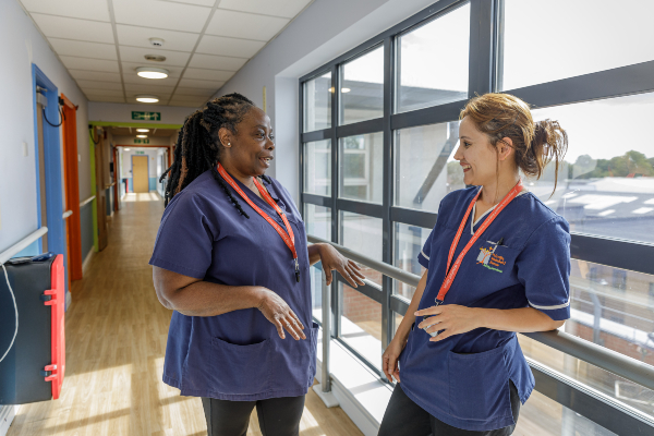 Two nurses talking in a corridor