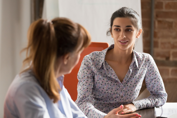 Image of two women talking to one another