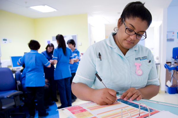 Health care assistant filling in paperwork