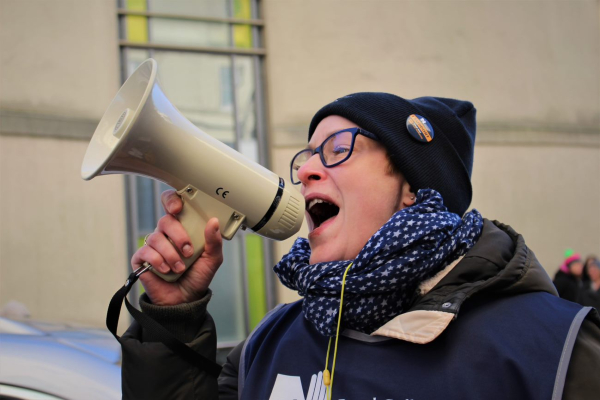 Nurse speaking into a megaphone at a picket