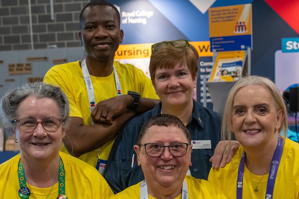 5 members of nursing staff smiling with an RCN banner behind them