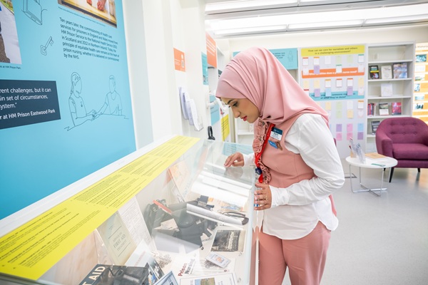 A student looking at a display case in the RCN Library