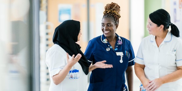 Three nurses talking in the corridor