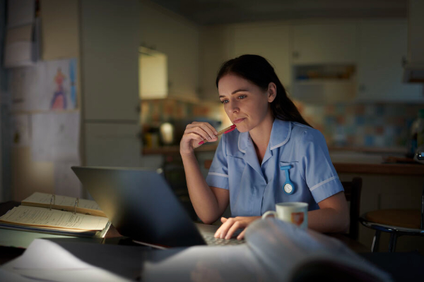 Image of a nurse studying at a laptop