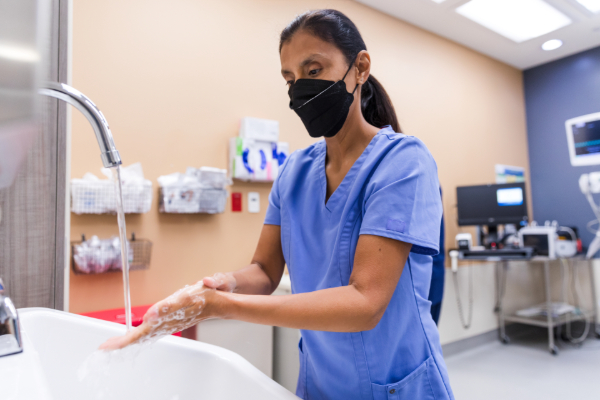 Image of a nurse washing her hands at a sink