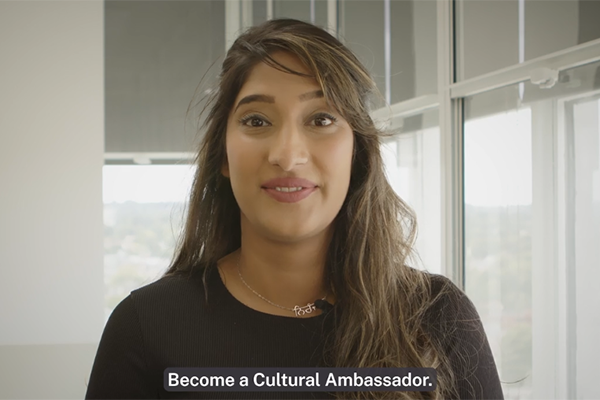 A still from the linked video of a cultural ambassador program attendee saying "Become a cultural ambassador"