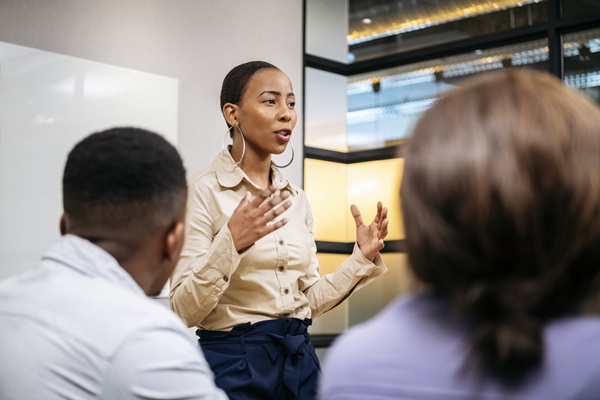 A woman standing up and speaking at a meeting