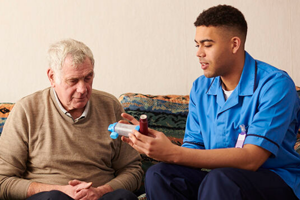 A community nurse talking about medication with an older patient.