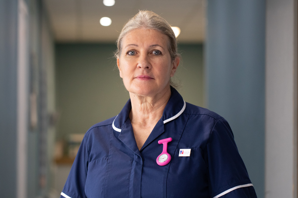 A nurse standing looking at the camera