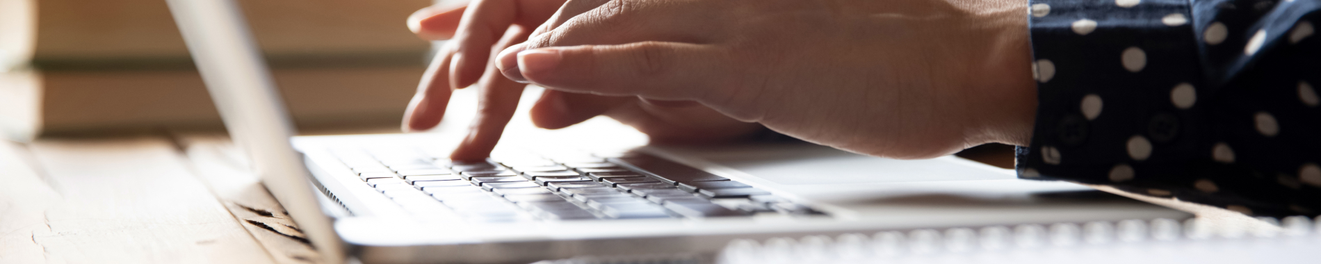 Image of hands typing on a laptop