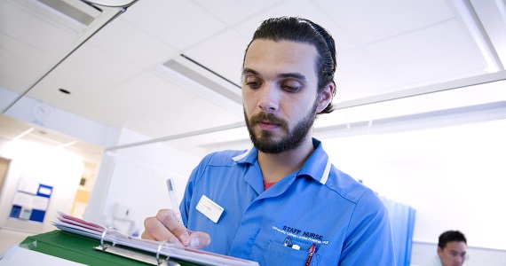 A nurse writing on a clipboard