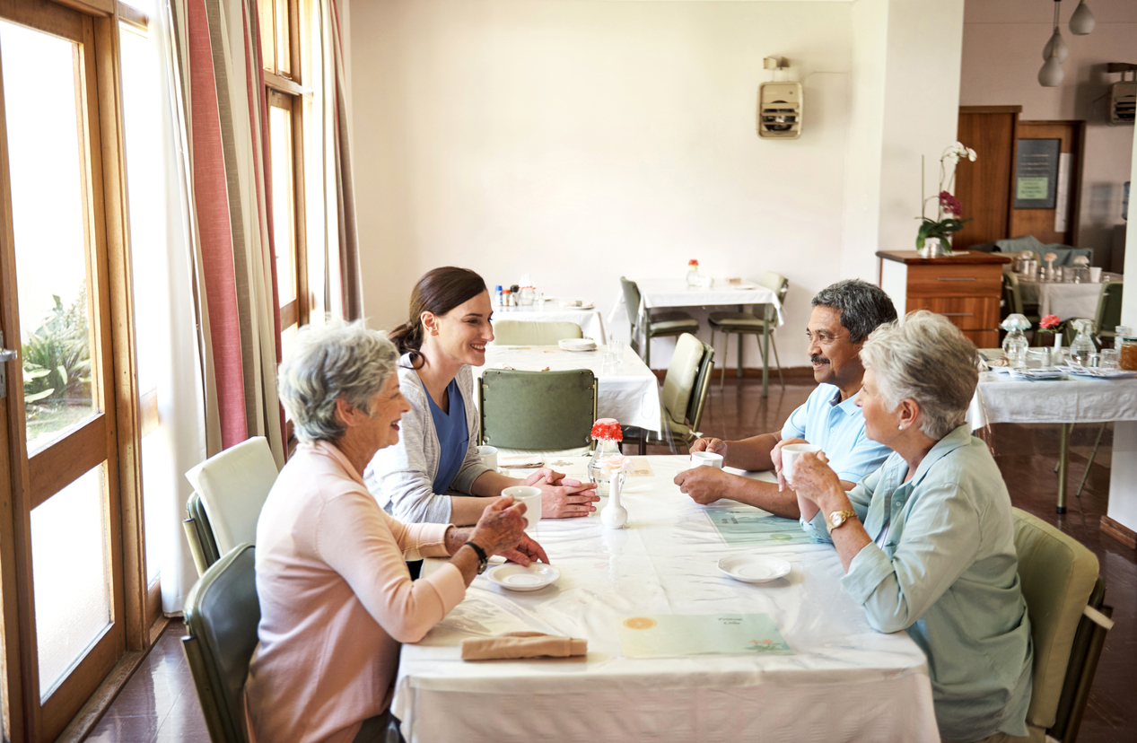 carer-with-elderly-people-by-the-table