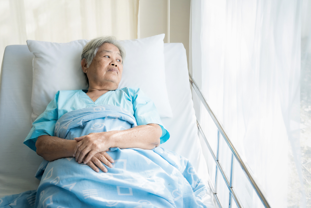 elderly asian woman in hospital bed