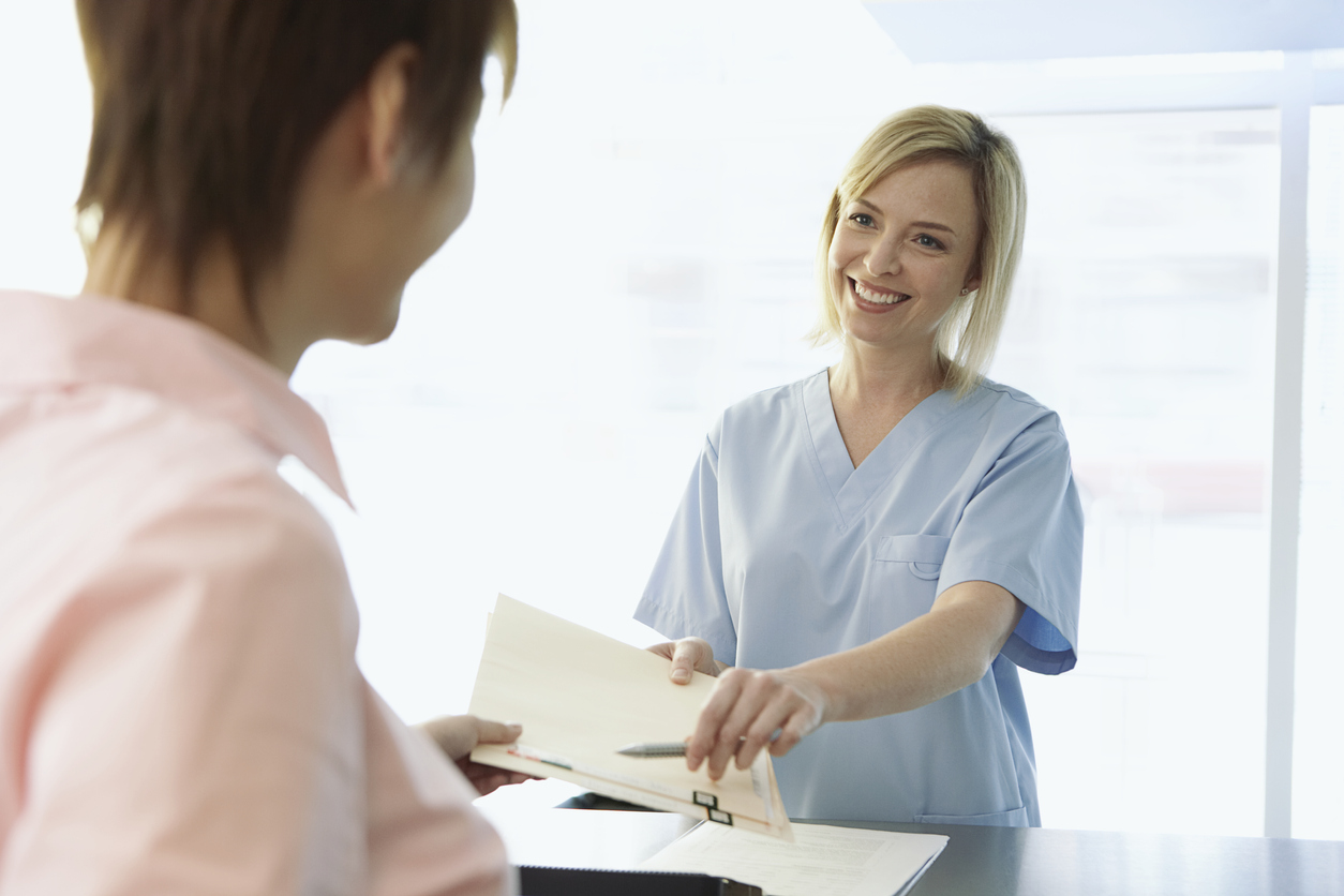 nurse handing in pen to patient