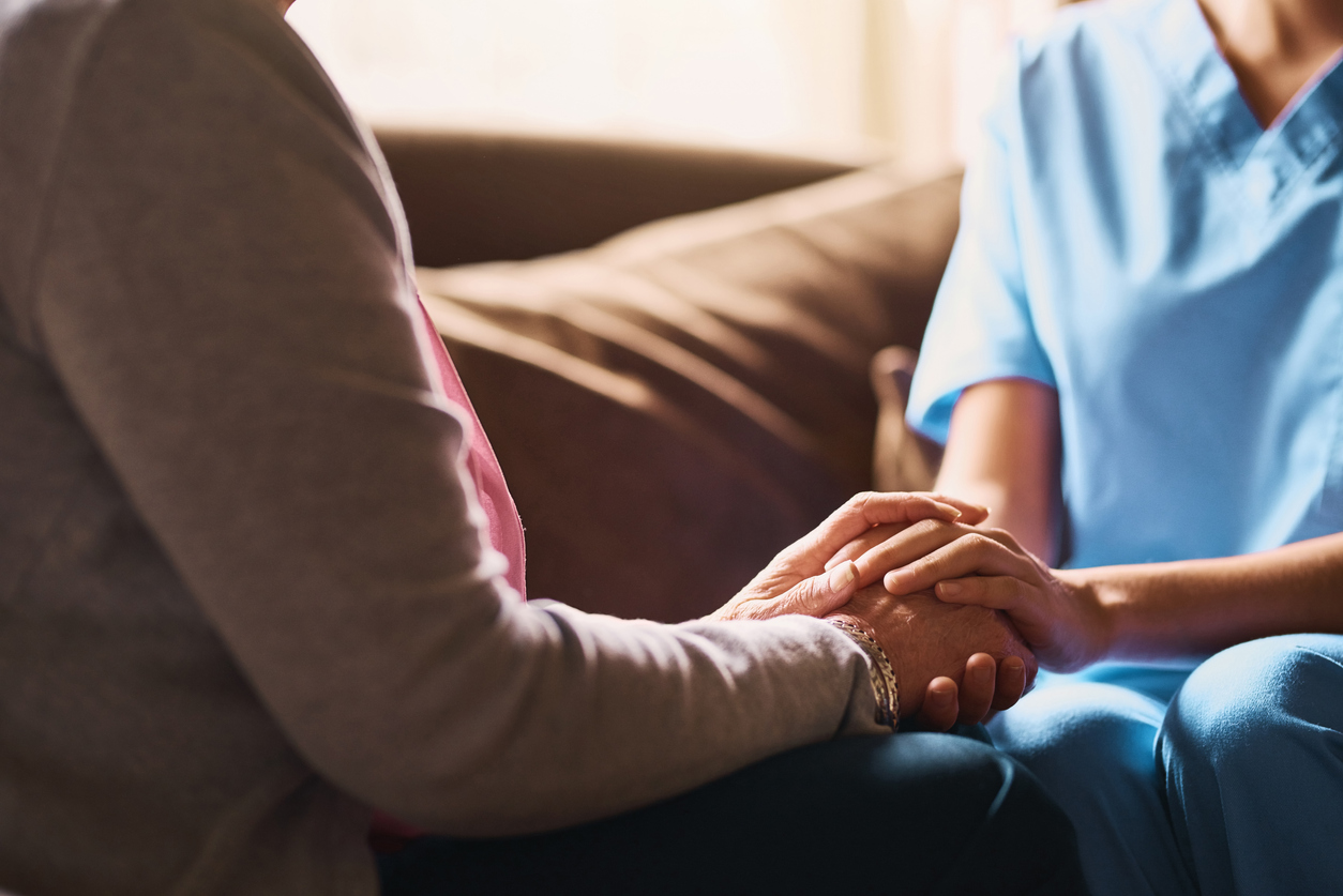 nurse holding hands of elderly person