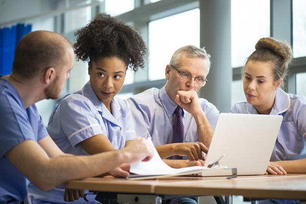 Group of nursing staff looking into a laptop